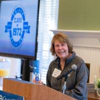 An alumni speaking at the podium.